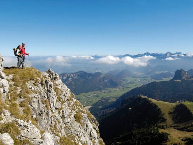 Wanderer stehen auf einem Berg mit Blick auf die Alpen