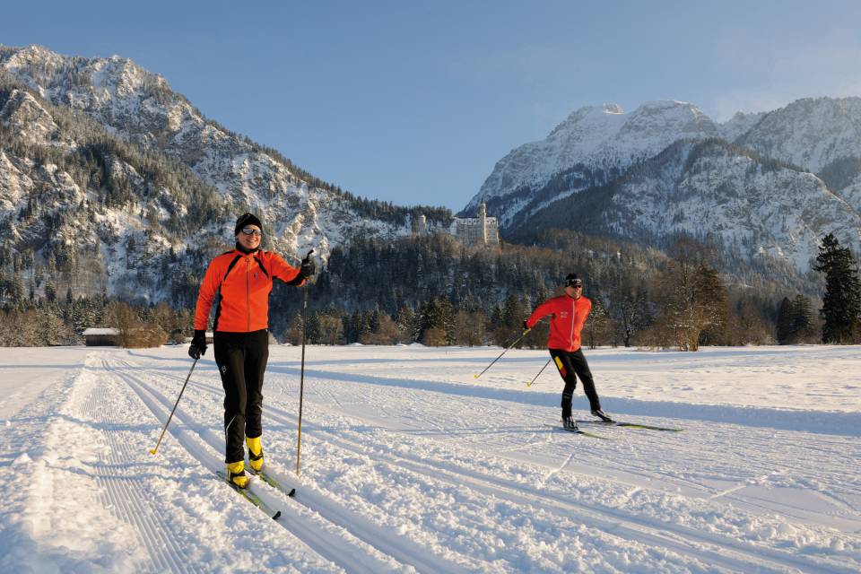 Skilangläufer in Loipen vor dem Schloss Neuschwanstein