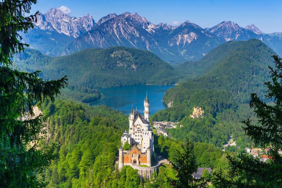Panoramablick auf das Schloss Neuschwanstein mit den Allgäuer Alpen