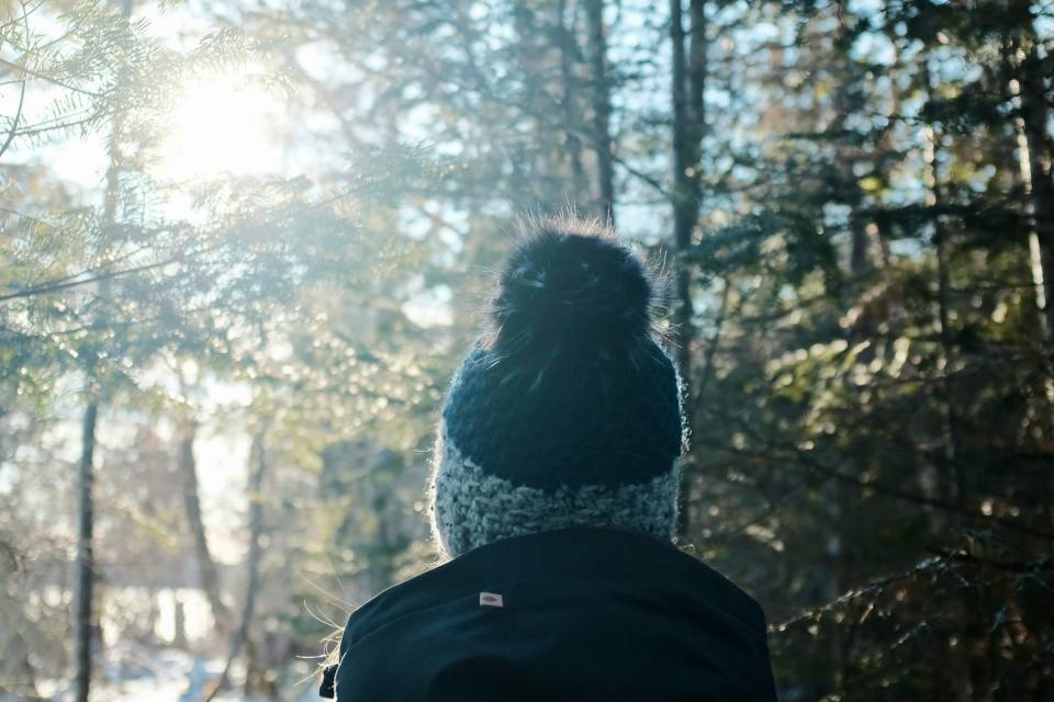 Person steht im Winter im Wald