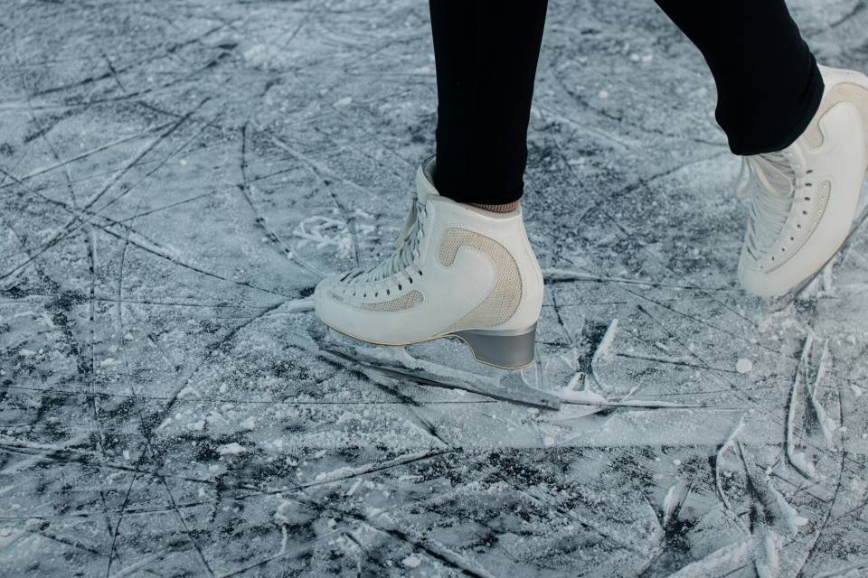 Frau mit Schlittschuhen auf dem Eis
